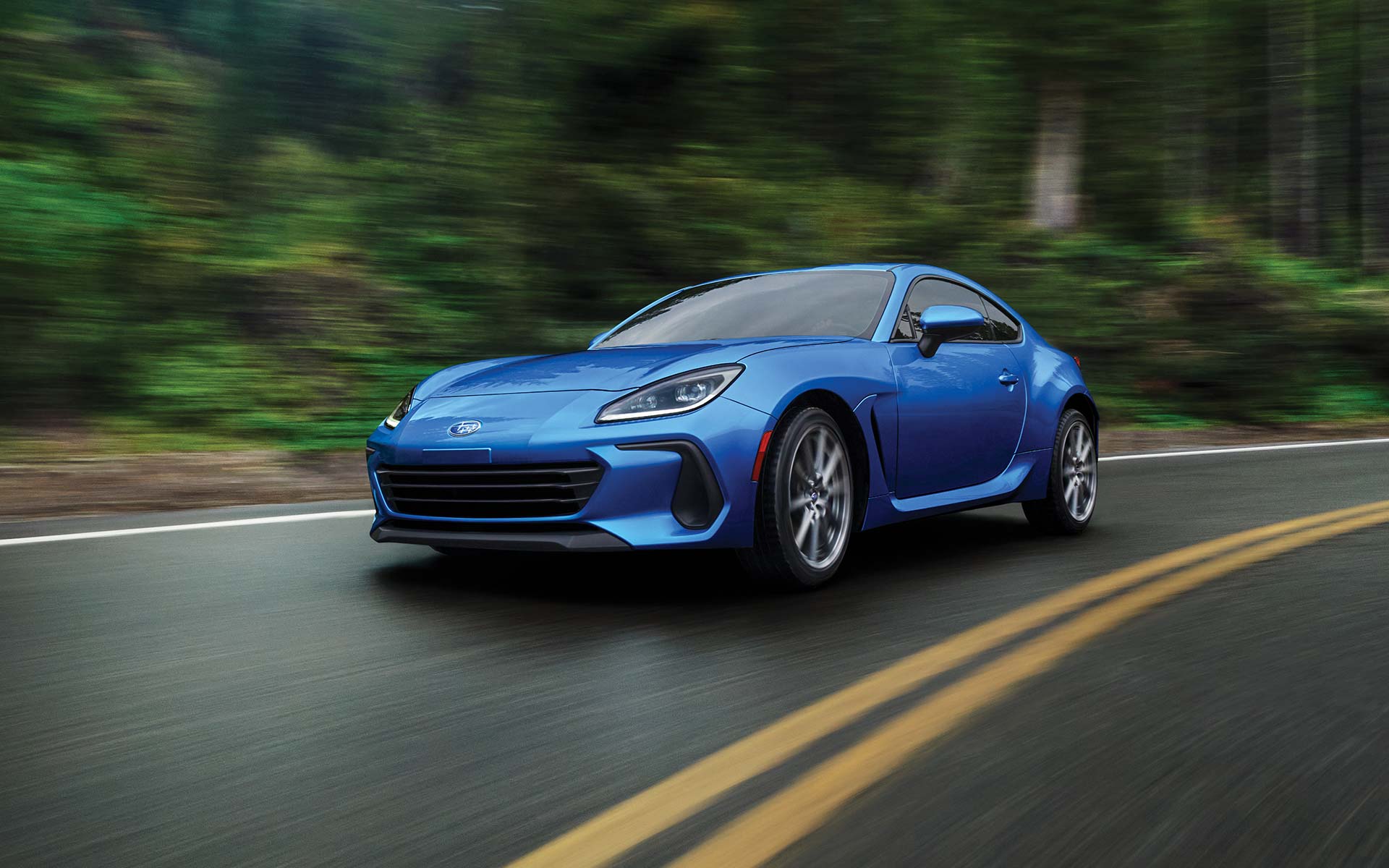 The 2022 Subaru BRZ Limited shown in WR Blue Pearl driving down forest highway.